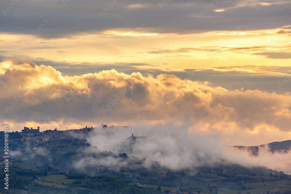 Village on a hill with clouds in a sunset Village on a hill with clouds in a sunset