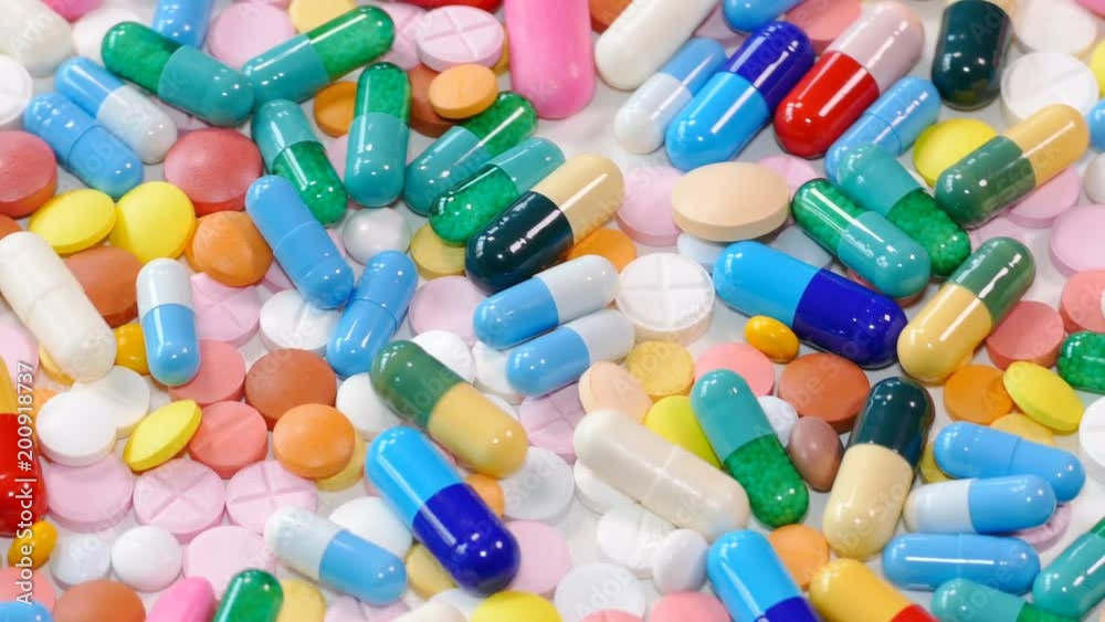 Colorful drugs and pills on white table, concept of medical treatment Colorful drugs and pills on white table, concept of medical treatment