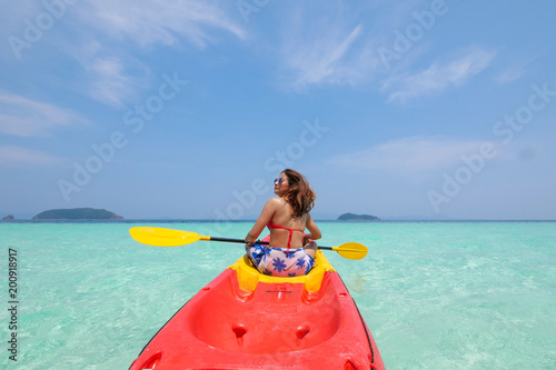 Asian woman on the kayak boat in Andaman blue sea and blue sky background location in Phuket island Thailand © chayathon2000