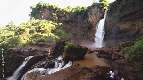 Beautiful landscape of Cimarinjung waterfall with visitor enjoying the view at Ciletuh Geopark, Sukabumi, West Java, Indonesia photo