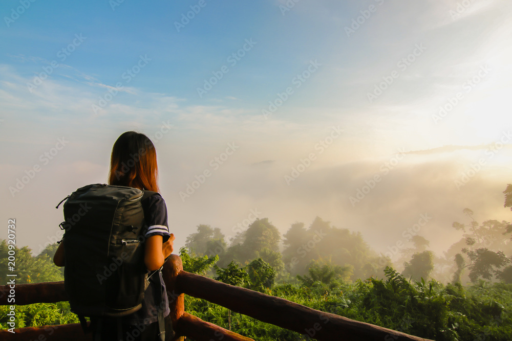 Happy young Girl Enjoy Backpacking.Watch the first light of the morning sun on the mountain.Feel refreshed and energize your life.