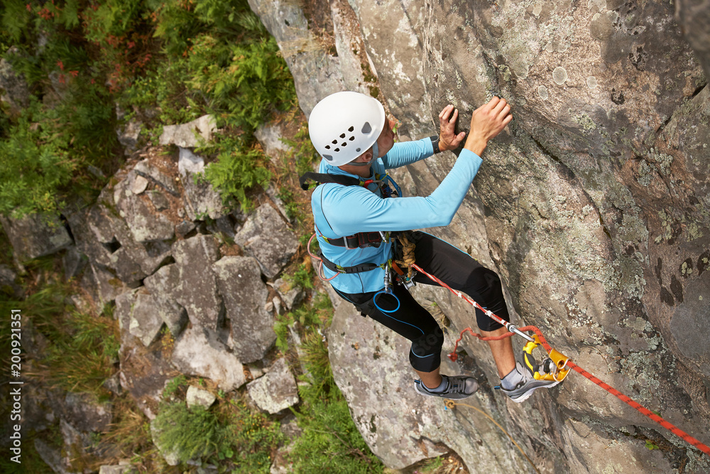 climber overcomes rocky wall