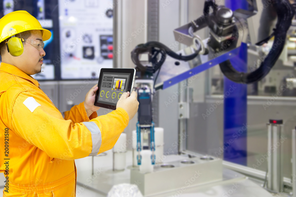 Industry 4.0 Robot concept .Engineers use laptop computers for machine maintenance, automation tools, robot arm at the factory. Industry 4.0 Robot concept .Engineers use laptop computers for machine maintenance, automation tools, robot arm at the factory.