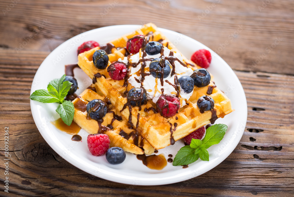 Fresh homemade waffles with blueberries and raspberries Fresh homemade waffles with blueberries and raspberries