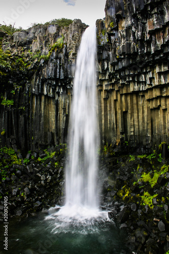 Großartiger Wasserfall mit Kaskaden und Basaltsteinen in island