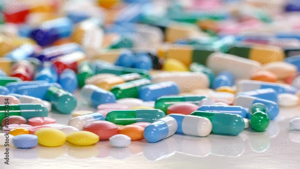 Colorful drugs and pills on white table, concept of medical treatment Colorful drugs and pills on white table, concept of medical treatment