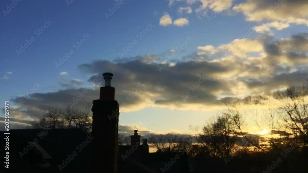 Wide shot timelapse from residential rooftop looking at sunset and clouds - high wind in spring Wide shot timelapse from residential rooftop looking at sunset and clouds - high wind in spring