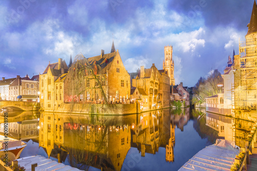 Belfry tower and medieval buildings along a canal in Bruges, Belgium