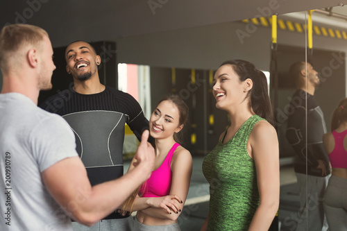 Group of sporty people talking at gym photo