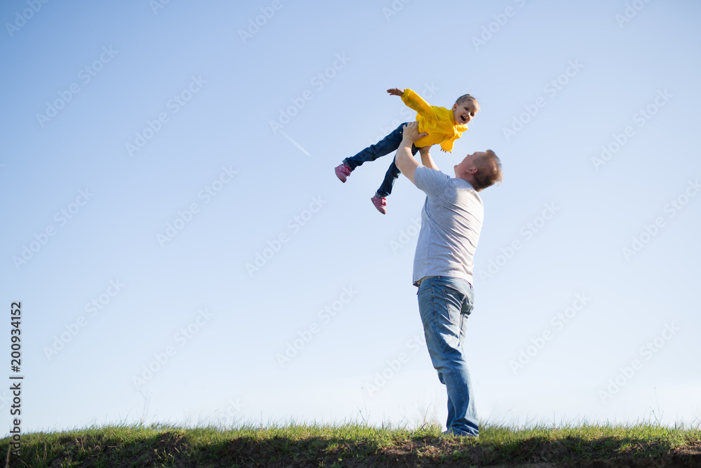 dad and daughter on the grass against the sky dad and daughter on the grass against the sky