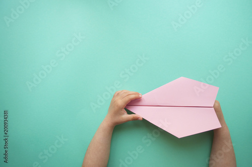 Paper plane in child's hands.