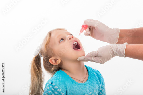 little girl on reception at the doctor receives the polio vaccine, a child being treated for influenza, the child takes the medicine in the hospitalception at the doctor takes antipyretic, anti-flu

