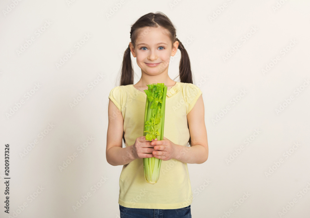 Happy little girl with celery over white background Happy little girl with celery over white background