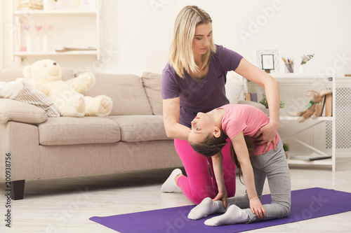 Young woman and child daughter training at home
