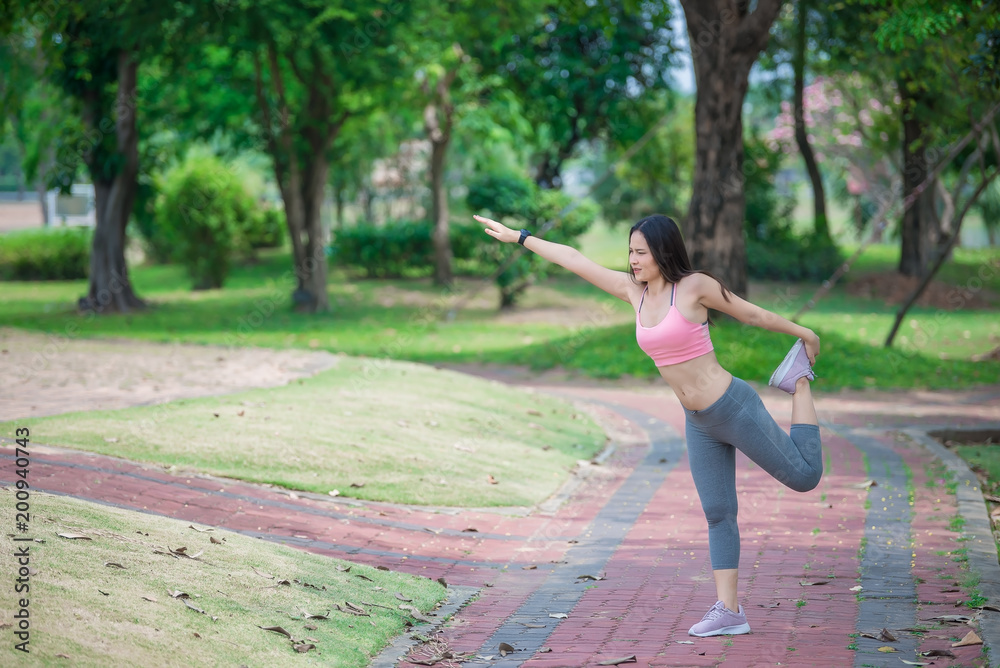 Asian sporty woman stretching body breathing fresh air in the park,Thailand people,Fitness and  exercise concept