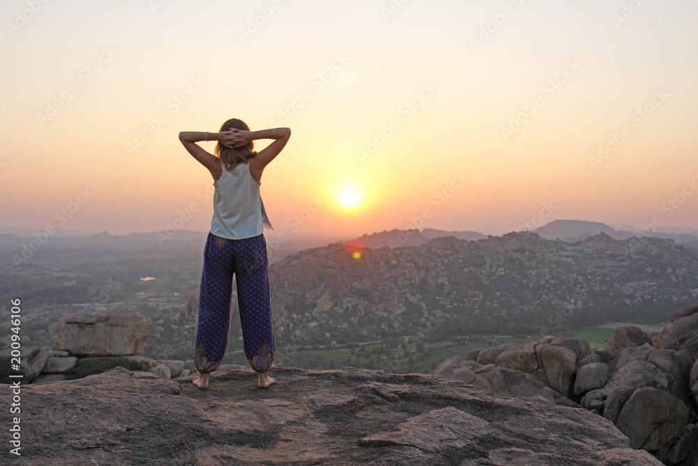 The girl at sunset. The girl stands with her back on the top of the ...