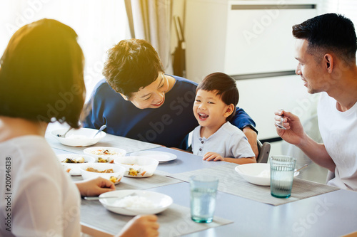 Konstfotografi Happy Asian extended family having dinner at home full of laughter and happiness