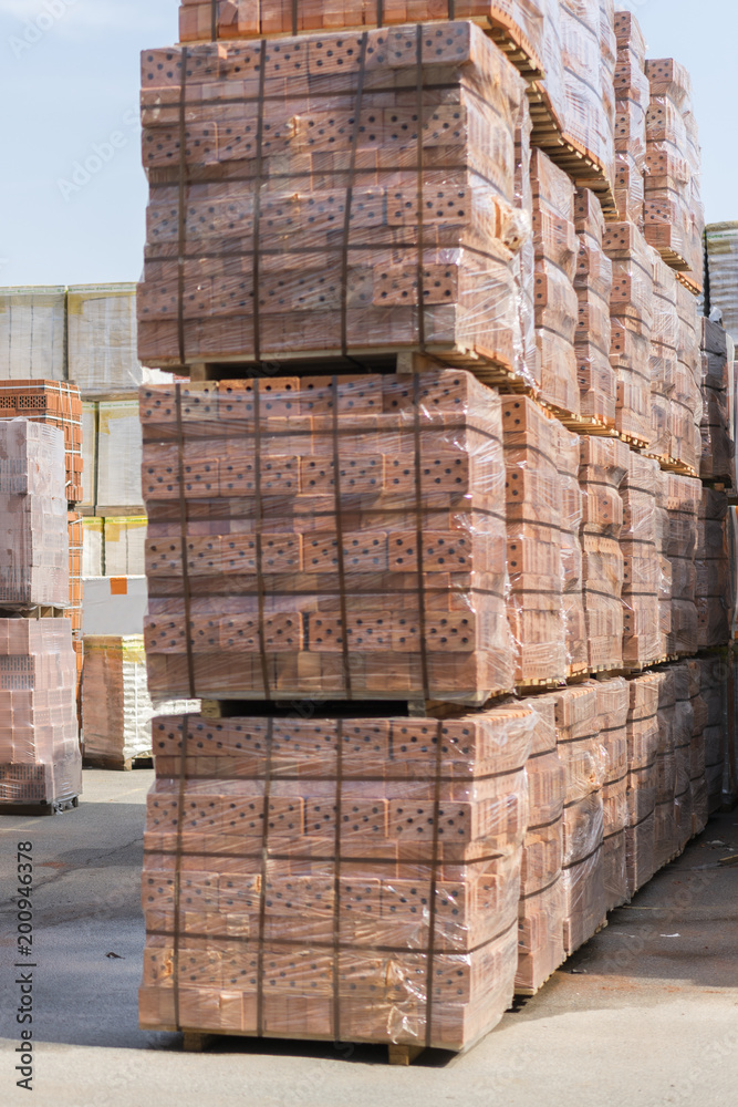 Several pallets with concrete brick stacked on top of each other in depot. new bricks on pallets Several pallets with concrete brick stacked on top of each other in depot. new bricks on pallets