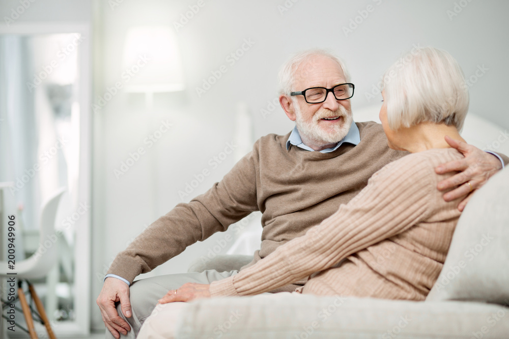 Senior couple. Pleasant aged man smiling while spending time with his wife Senior couple. Pleasant aged man smiling while spending time with his wife