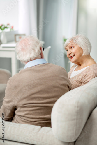 Pleasant talk. Positive senior couple looking at each other while having a pleasant conversation