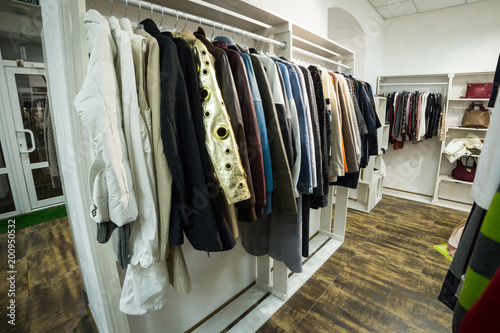 Clothes hang on a shelf in a designer store © bondvit