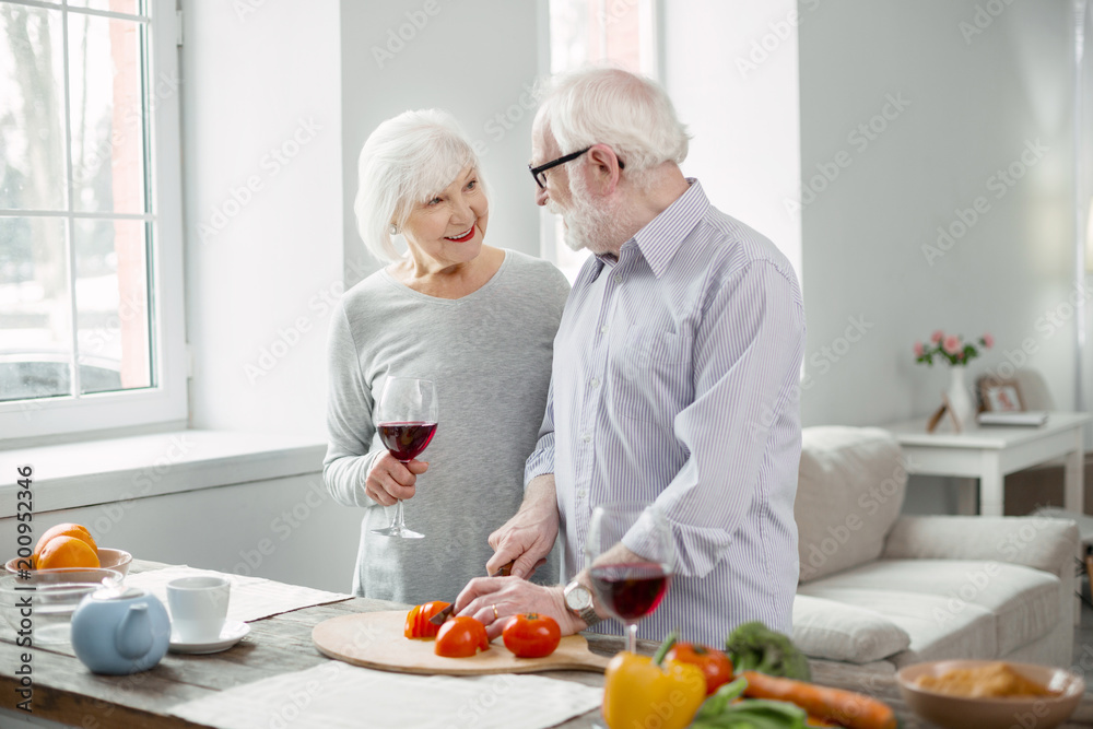 Wonderful mood. Delighted aged people talking to each other while preparing dinner