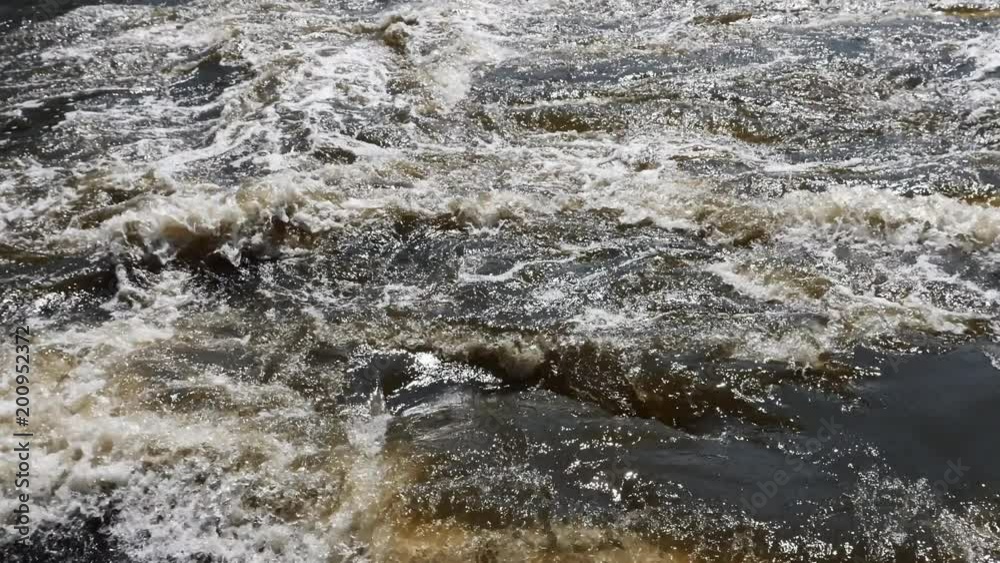 Streams of water on the river dam splashing out from the gateway and form waves Streams of water on the river dam splashing out from the gateway and form waves