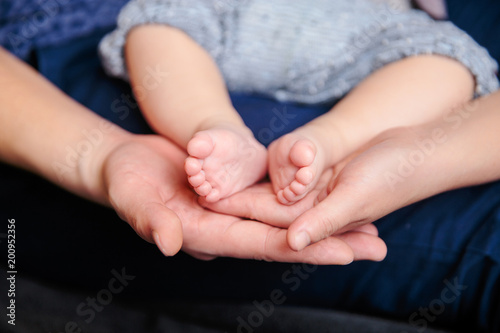 petits pieds de bébé tenues par les mains de ses parents