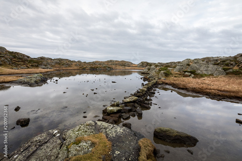 Pond by the trail, at the Rovaer archipelago, island in Haugesund, Norway. Stones making a path through the water. © Lillian