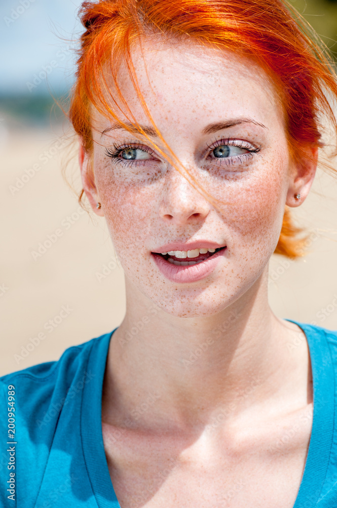 Closeup outdoor portrait of a young beautiful redhead freckled woman thinking about something Closeup outdoor portrait of a young beautiful redhead freckled woman thinking about something