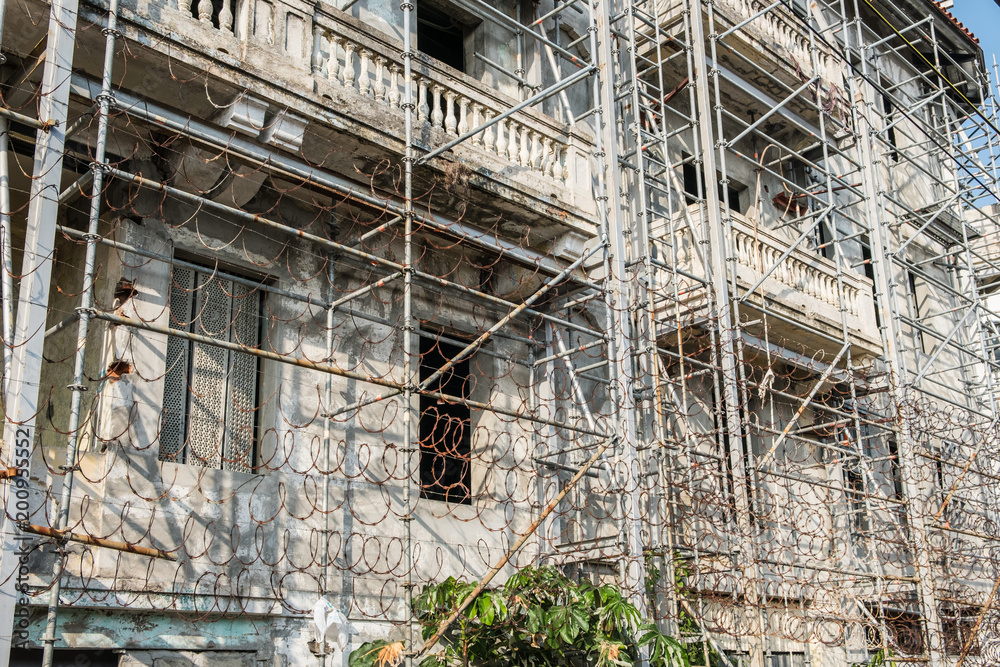 scaffolding and barbwire on old building facade 