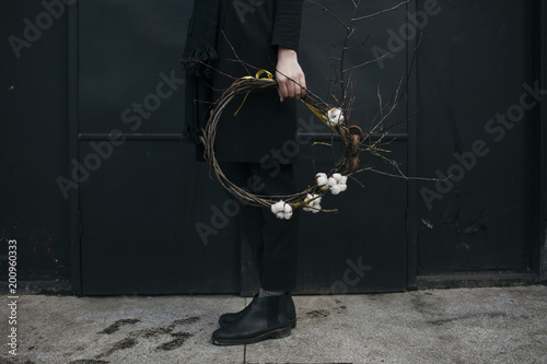 Low section of man holding cotton boll wreath outdoors photo