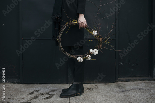 Low section of man holding cotton boll wreath outdoors