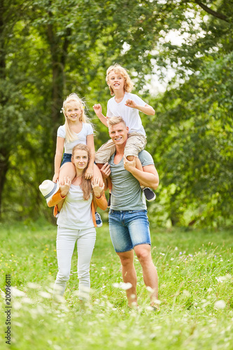 Eltern tragen ihre Kinder huckepack