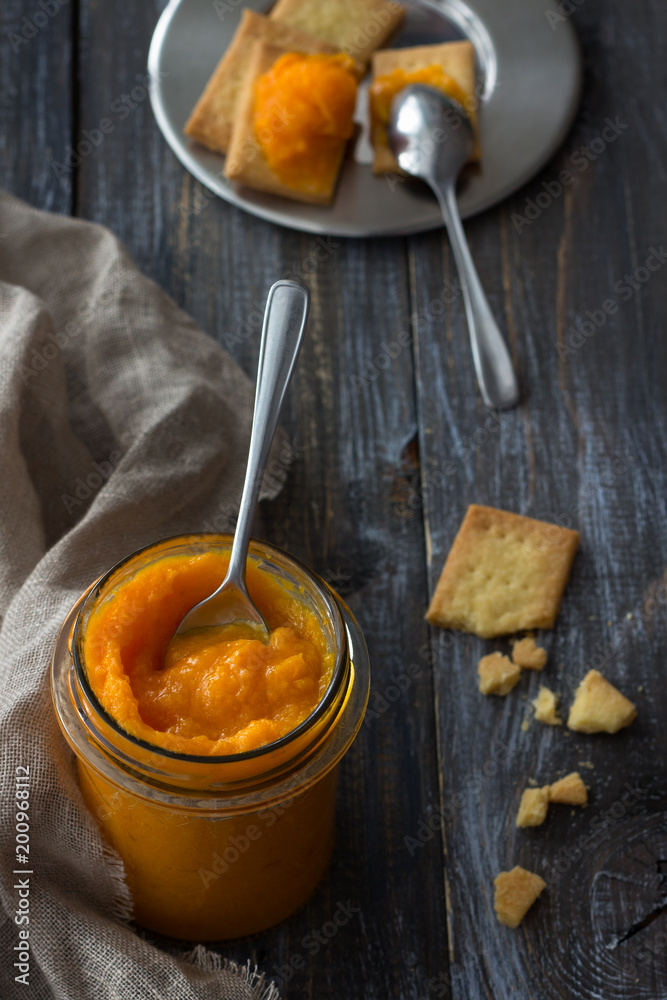 Healthy raw orange jam with dried apricots in a glass jar with cookies on a wooden table. diet food. selective focus. rustic style Healthy raw orange jam with dried apricots in a glass jar with cookies on a wooden table. diet food. selective focus. rustic style