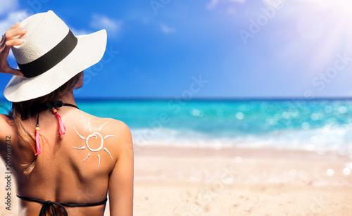 Girl With Suntan Lotion Shaped Sun In The Beach