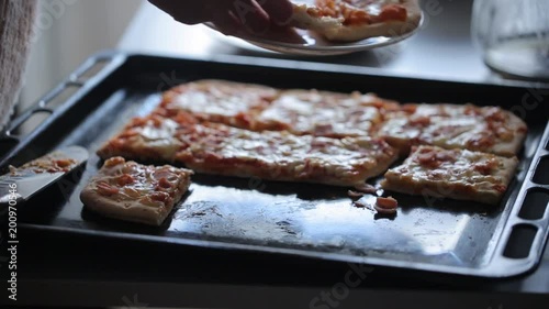 Taking slice of pizza on the baking tray photo