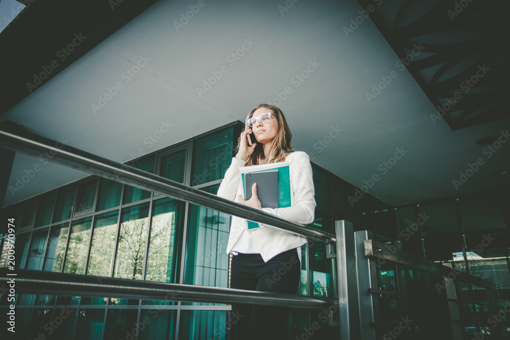 Fototapeta premium young blonde business woman outdoor in the city with smart phone