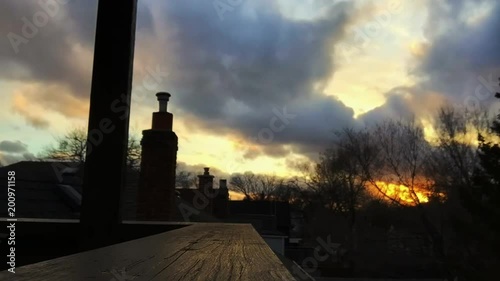 TIMELAPSE of high winds and sun setting from rooftop view photo