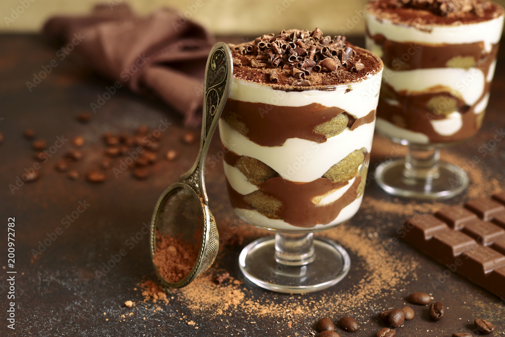 Traditional italian dessert tiramisu with chocolate sauce in a glass. Traditional italian dessert tiramisu with chocolate sauce in a glass.