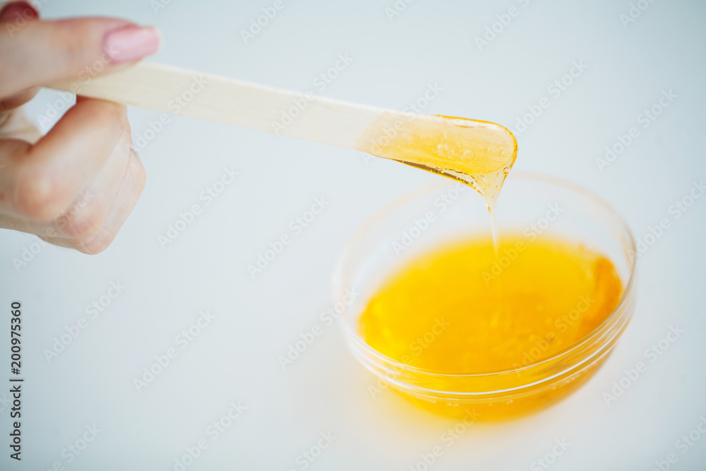 Wax and stick for depilation on white background top view Wax and stick for depilation on white background top view