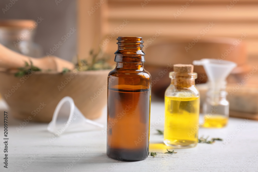 Bottles with essential oils on wooden table Bottles with essential oils on wooden table