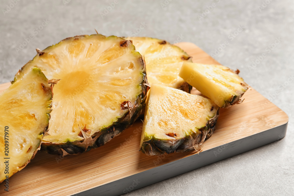 Slices of fresh pineapple on wooden board Slices of fresh pineapple on wooden board