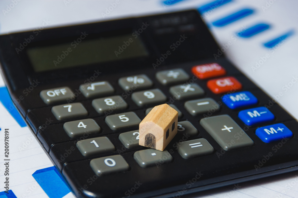 Mortgage Loans Concept with Wooden House and Calculator on White Background with Diagram. Mortgage Loans Concept with Wooden House and Calculator on White Background with Diagram.