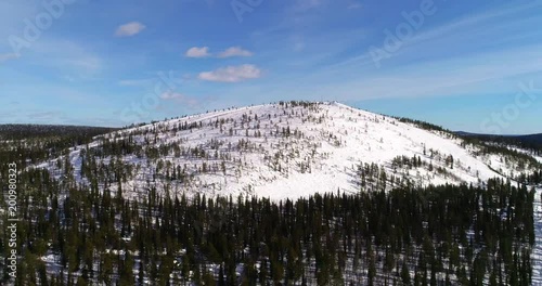 Ski resort, C4k aerial sideway view of a frozen sallatunturi mountain fjeld on a sunny winter day, in Salla, Lapland, Finland photo