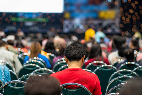 Rear view of Audience in the conference hall or seminar meeting which have Speakers on the stage, business and education about investment concept