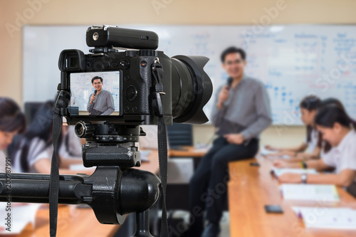 Professional digital Mirrorless camera on the tripod recording video blog of Asian teacher in the classroom,Camera for photographer or Video and Technology Live Streaming concept,University education photo