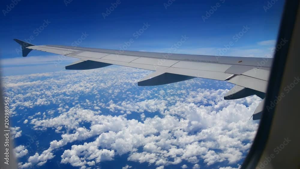 Travel video View from the airplane window through the wings and engine While flying through the cloud and bluesky in transportation or travel concept. Travel video View from the airplane window through the wings and engine While flying through the cloud and bluesky in transportation or travel concept.