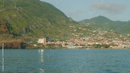 Madeira island with its city, roads and mountains. View from sailing yacht board. photo