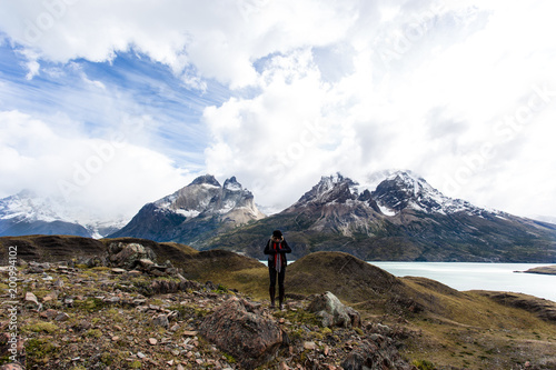 woman standing with arms wide open with Torres del Paine mountain range in the background